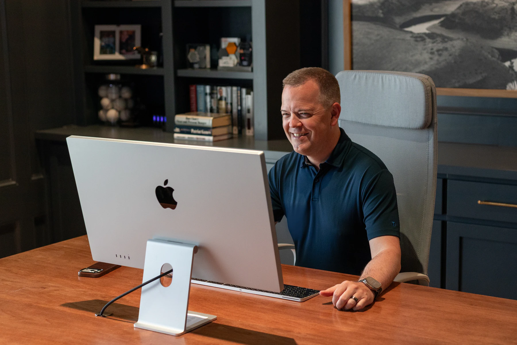 Aaron Klein smiling at his desk in his study.